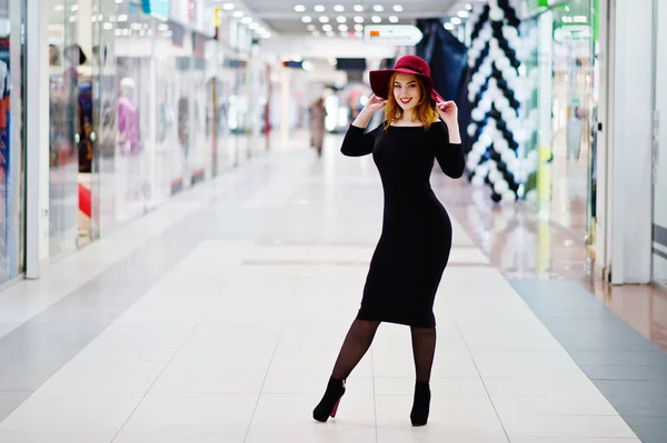 Moda chica pelirroja desgaste en vestido negro y sombrero rojo posado en —  Fotos de Stock