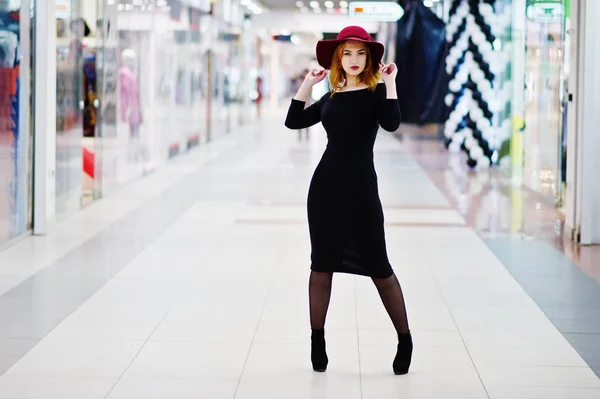 Moda chica pelirroja desgaste en vestido negro y sombrero rojo posado en —  Fotos de Stock