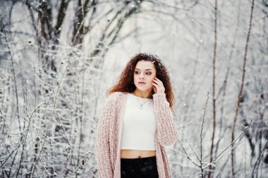 Kıvırcık esmer kız arka plan yağan kar, sıcak knitte aşınma