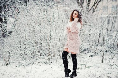 Kıvırcık esmer kız arka plan yağan kar, sıcak knitte aşınma