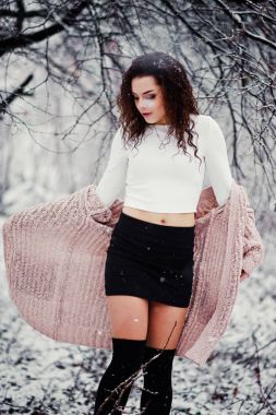 Kıvırcık esmer kız arka plan yağan kar, sıcak knitte aşınma