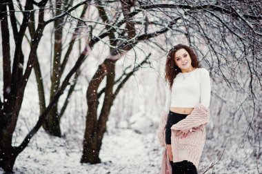 Kıvırcık esmer kız arka plan yağan kar, sıcak knitte aşınma