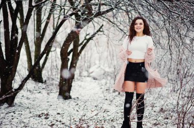 Kıvırcık esmer kız arka plan yağan kar, sıcak knitte aşınma