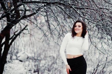 Kıvırcık esmer kız arka plan yağan kar, siyah mini aşınma 