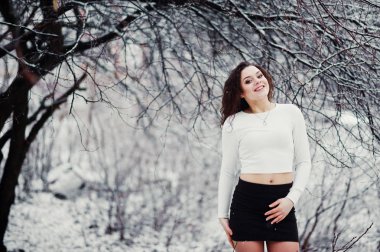 Kıvırcık esmer kız arka plan yağan kar, siyah mini aşınma 