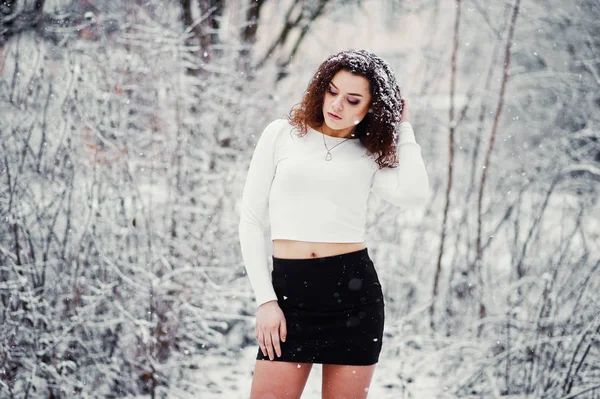 Curly brunette girl background falling snow, wear on black mini — Stock Photo, Image