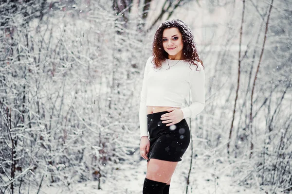 Curly morena menina fundo caindo neve, desgaste no mini preto — Fotografia de Stock