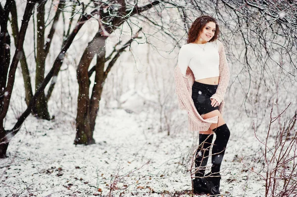 Curly brunette meisje achtergrond vallende sneeuw, slijtage van warme knitte — Stockfoto