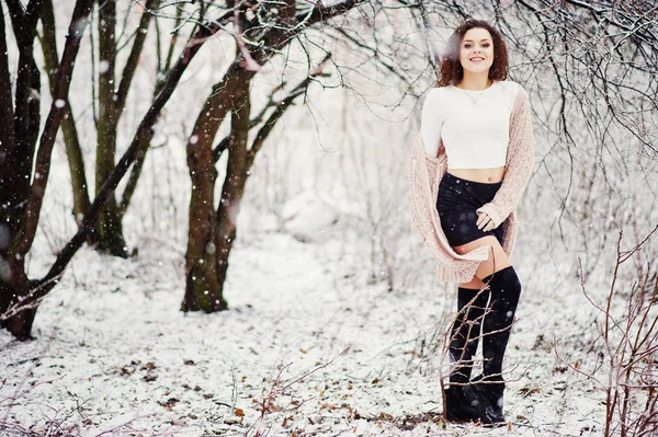 Lockig brunett flicka bakgrund faller snö, slitage på varma sticka — Stockfoto