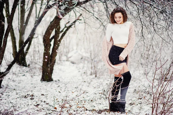 Curly brunette meisje achtergrond vallende sneeuw, slijtage van warme knitte — Stockfoto