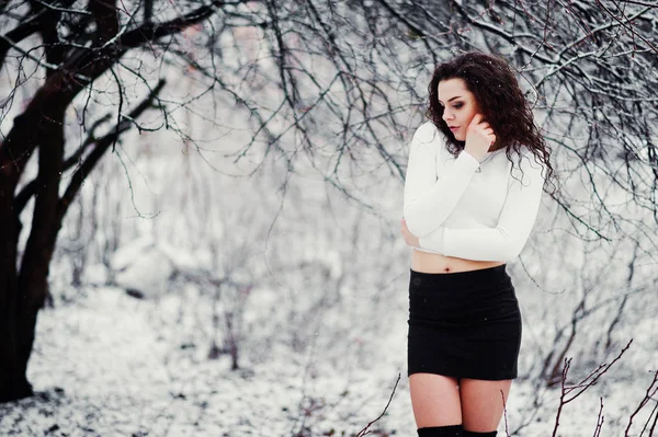 Curly morena menina fundo caindo neve, desgaste no mini preto — Fotografia de Stock
