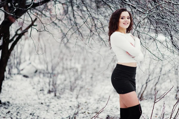 Кудрявая брюнетка девушка фон падающий снег, носить на черный мини — стоковое фото