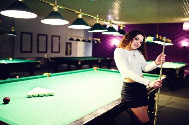 Genç kıvırcık kız Bilardo masası poz verdi. Seksi model siyah 