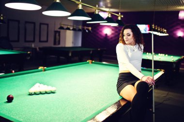 Genç kıvırcık kız Bilardo masası poz verdi. Seksi model siyah 