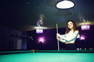 Genç kıvırcık kız Bilardo masası poz verdi. Seksi model siyah 