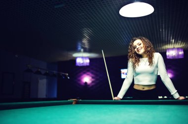 Genç kıvırcık kız Bilardo masası poz verdi. Seksi model siyah 