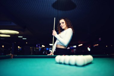 Genç kıvırcık kız Bilardo masası poz verdi. Seksi model siyah 