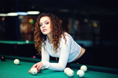 Genç kıvırcık kız Bilardo masası poz verdi. Seksi model siyah 