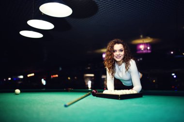 Genç kıvırcık kız Bilardo masası poz verdi. Seksi model siyah 