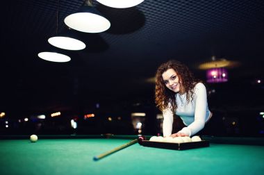 Genç kıvırcık kız Bilardo masası poz verdi. Seksi model siyah 