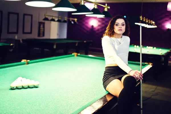 Σγουρό κορίτσι θέτει κοντά στο τραπέζι μπιλιάρδου. Σέξι μοντέλο σε μαύρο — Φωτογραφία Αρχείου
