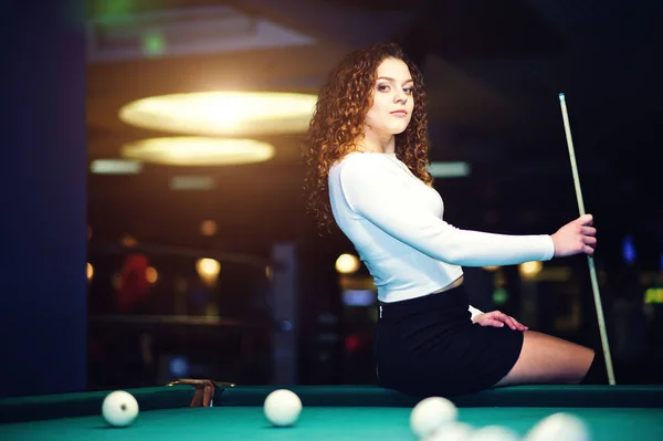 Krullend meisje poseerde in de buurt van de biljarttafel. Sexy model op zwart — Stockfoto