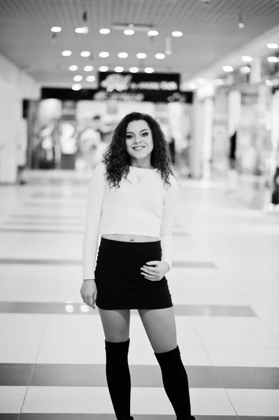 Молодая кудрявая модель девушка позировала на мини-юбке в большом торговом центре — стоковое фото