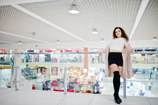 Joven modelo rizado chica posó en mini falda en un gran centro comercial —  Fotos de Stock