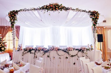 Tablo yeni evli pek çok çiçek ile şık düğün kemer.