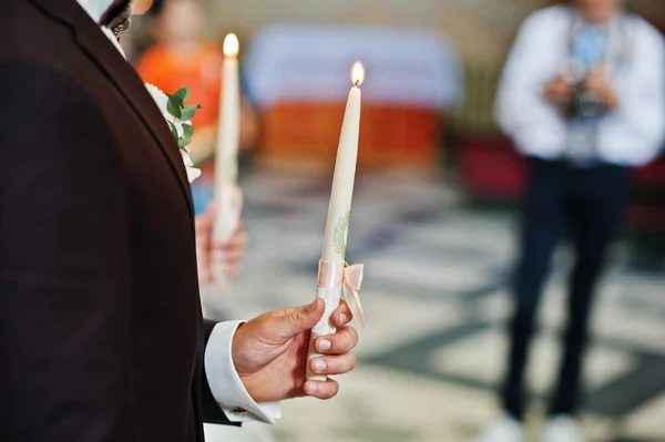 Groom avec mariée tenant des bougies allumées à portée de main sur le chur de mariage — Photo