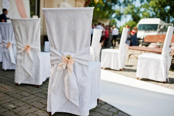 Wedding chairs with pink bows on site wedding ceremony. — Stock Photo, Image
