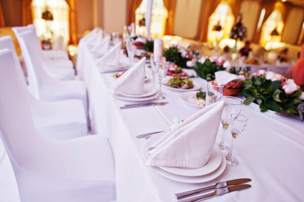 Table setting with plates and cutlery set at wedding table of ne
