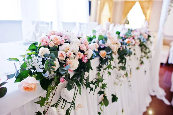 Bloemen op tafel voor jonggehuwden bij bruiloft receptie. — Stockfoto