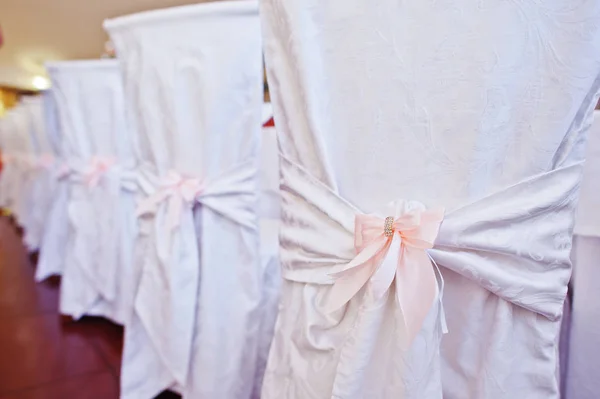 Sillas de boda con lazos rosados en el restaurante . — Foto de Stock