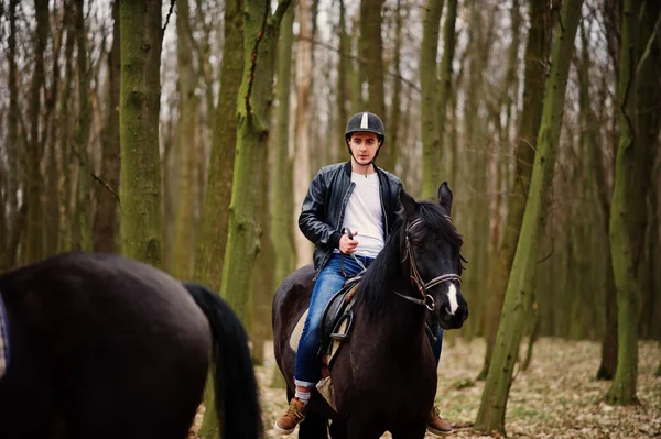 Stijlvolle jongeman rijden op paarden op herfst bos. — Stockfoto