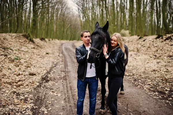 Jonge stijlvolle paar verliefd in de buurt van paard op herfst bos. — Stockfoto