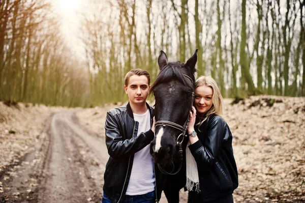 Jonge stijlvolle paar verliefd in de buurt van paard op herfst bos. — Stockfoto