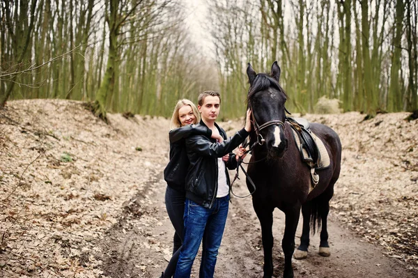 Jonge stijlvolle paar verliefd in de buurt van paard op herfst bos. — Stockfoto