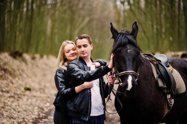 Jovem casal elegante no amor perto de cavalo na floresta de outono . — Fotografia de Stock
