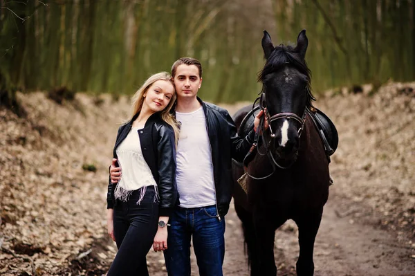 Jonge stijlvolle paar verliefd in de buurt van paard op herfst bos. — Stockfoto