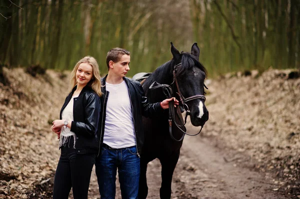 Young stylish couple in love near horse at autumn forest. — Stock Photo, Image