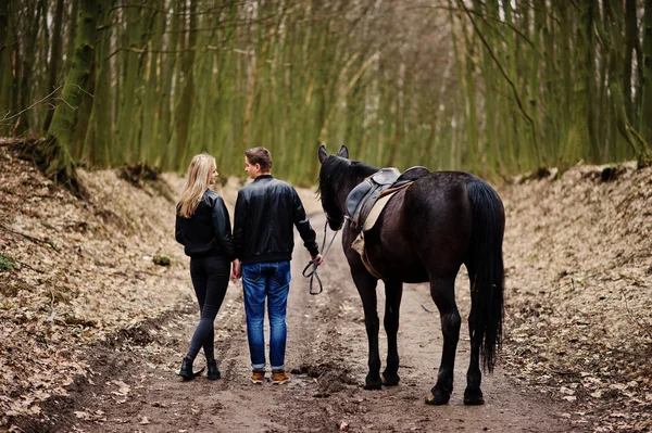 Back of young stylish couple in love walking with horse at autum — Stock Photo, Image