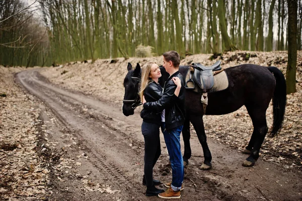 Unga snygga par i kärlek nära häst på hösten skogen. — Stockfoto