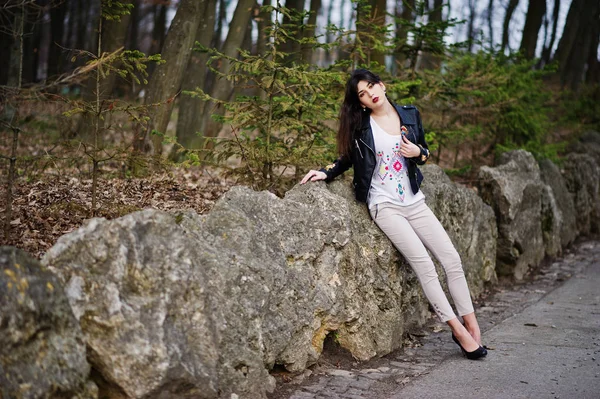 Brünettes Zigeunermädchen posierte gegen Steine im Park. Verschleiß am Modell — Stockfoto