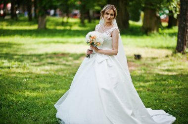 Sevimli sarışın gelin düğün buket güneşli Park ile.