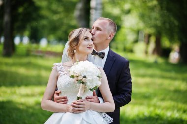 Şık Düğün çifti güneşli weddin üzerinde yeşil park sarılma