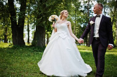 Şık Düğün çifti güneşli weddin üzerinde yeşil park sarılma