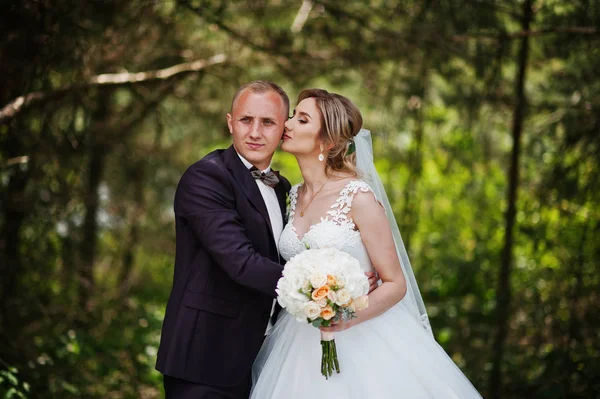 Fashionable wedding couple hugging at forest on sunny wedding da — Stock Photo, Image