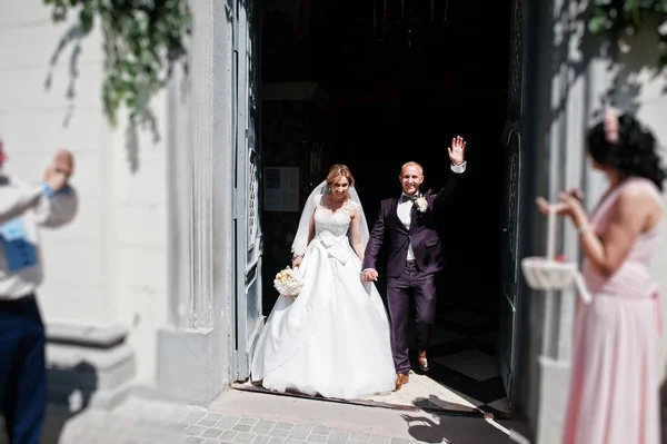 Весільна пара вихід з церкви після церемонії одруження . — стокове фото
