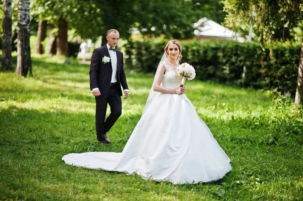 Divatos esküvői pár átölelve a zöld parkban a napsütéses esküvői — Stock Fotó